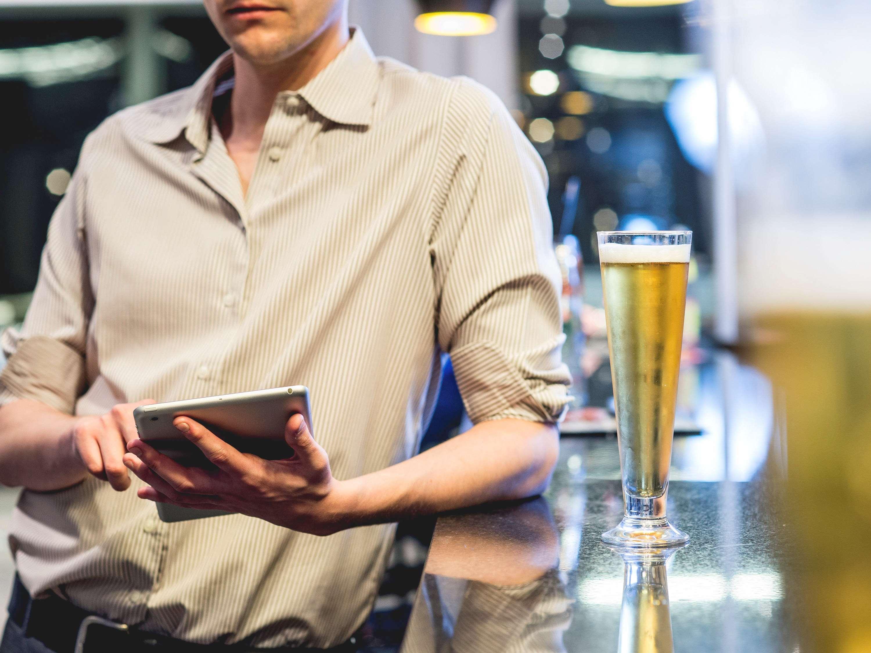Pullman Santiago Vitacura Экстерьер фото A bartender using a tablet computer